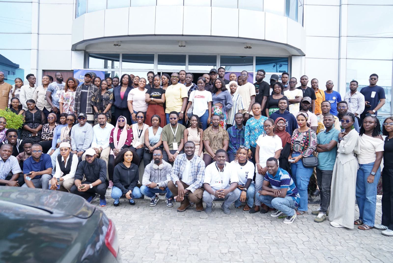 A large group photo of the AltSchool cohort gathered outside a building