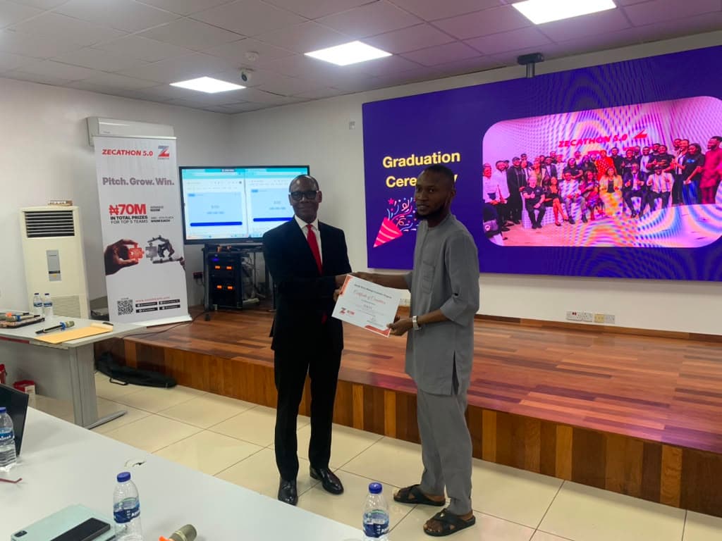 Olatunji holding his Beyond Limits business incubation certificate